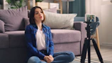 a woman sitting on the floor in front of a couch