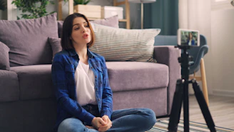 a woman sitting on the floor in front of a couch