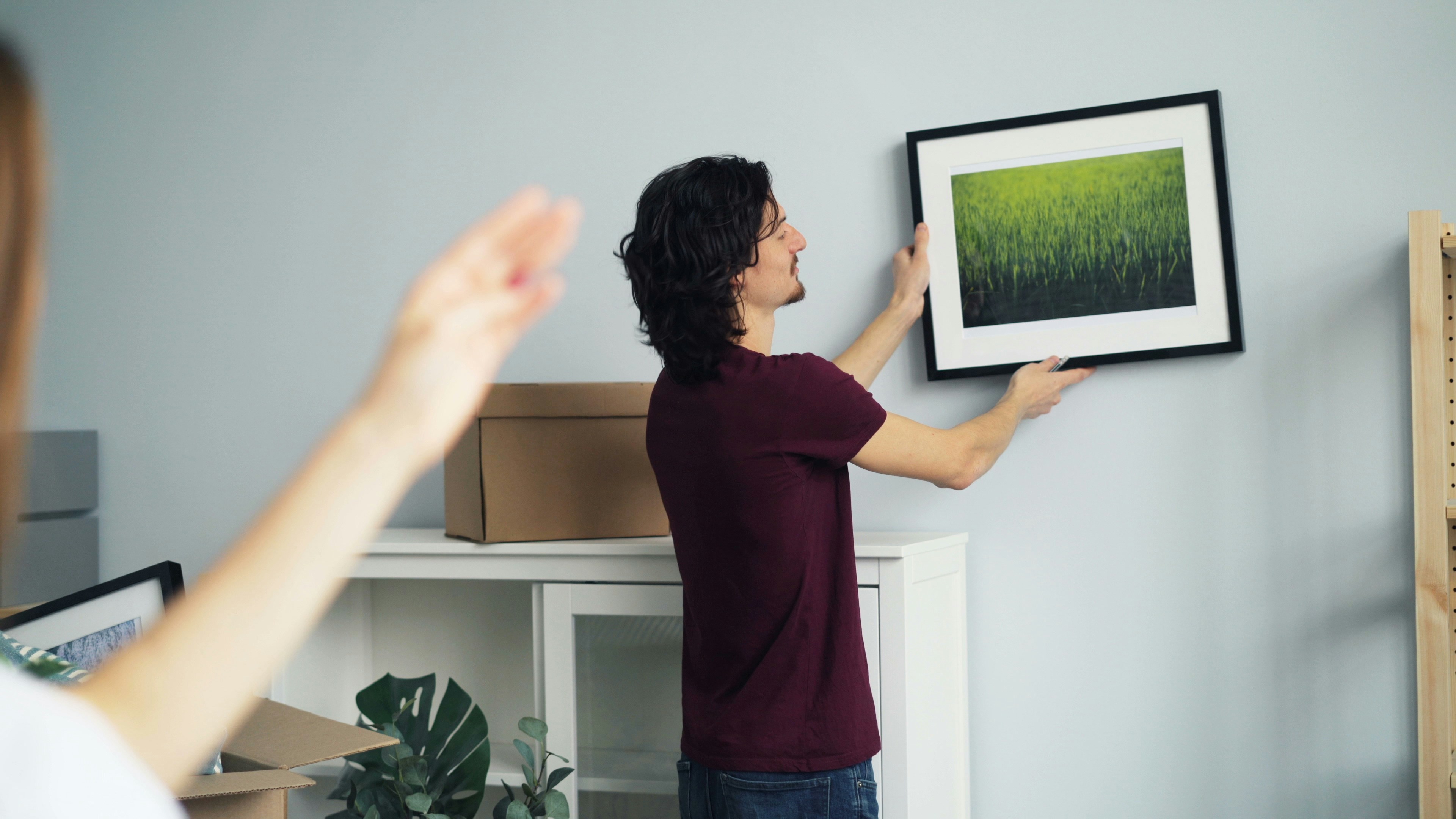 a man holding up a picture in front of a woman