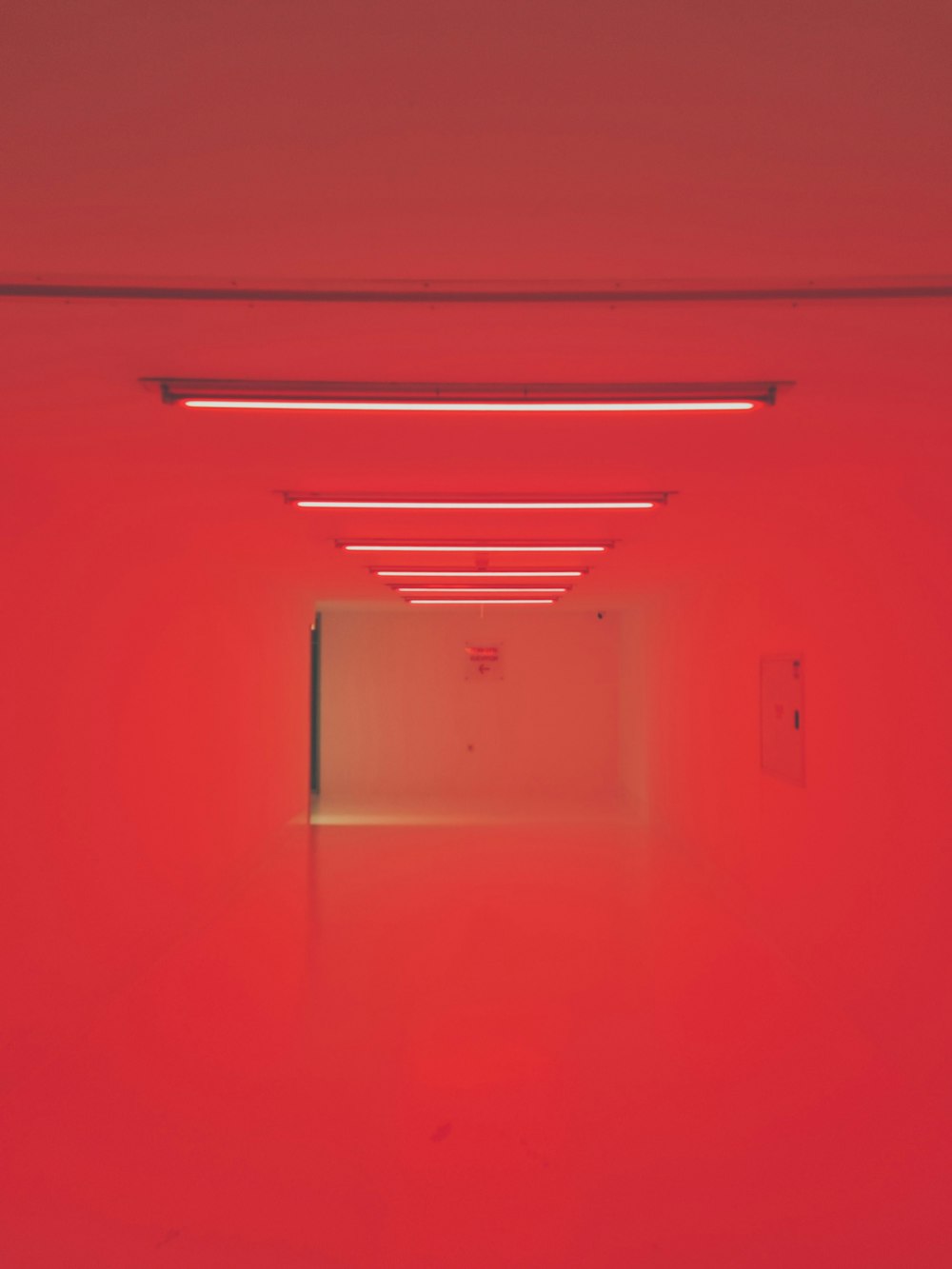 an empty room with red walls and lights