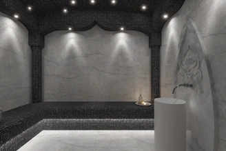 a bathroom with a black and white tiled wall