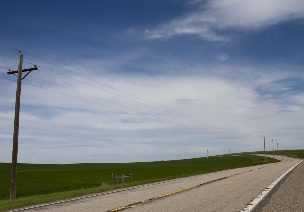 an empty road with power lines in the distance