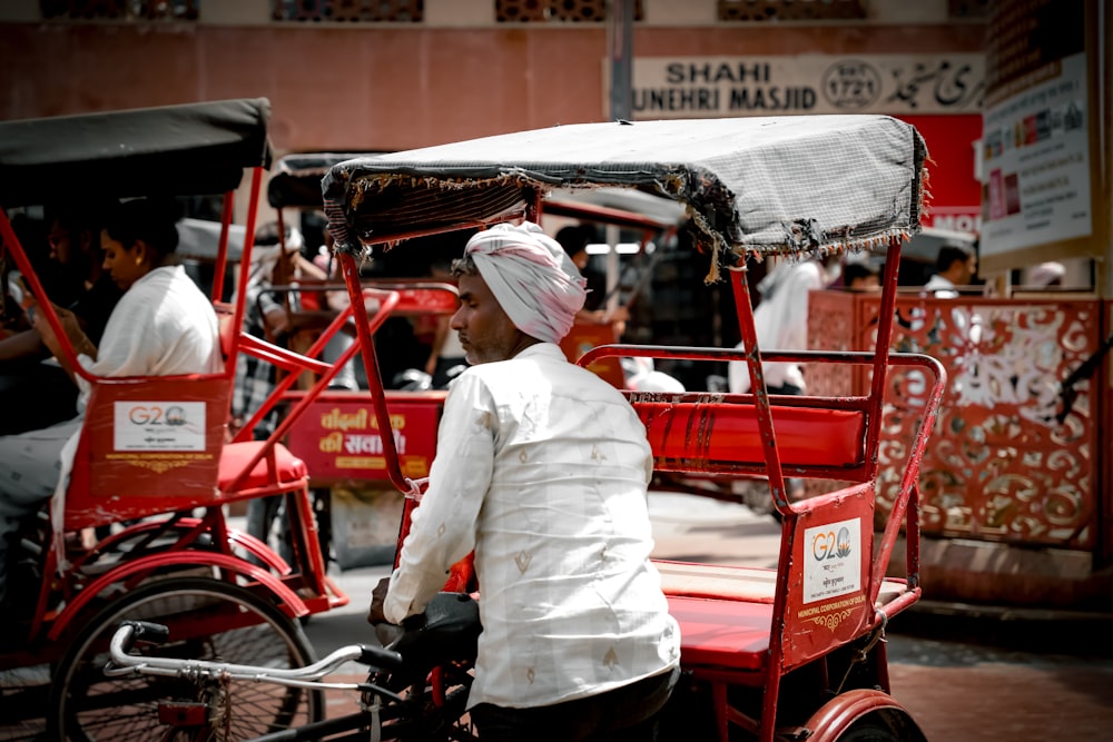 a man riding a rickshaw with a white turban on it