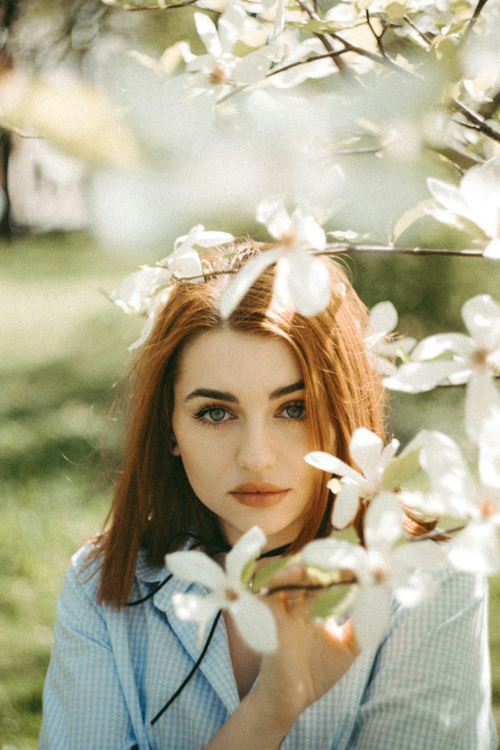 a woman is posing for a picture under a tree