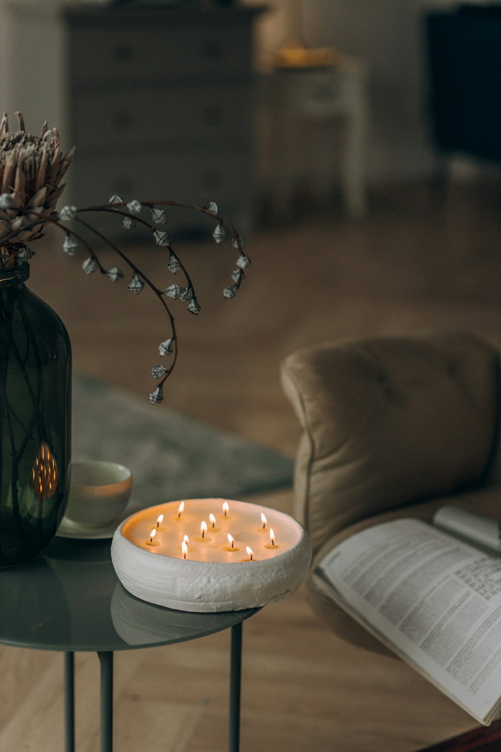 una mesa con una vela y un libro sobre ella