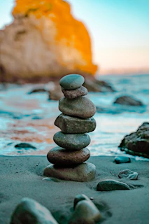 a stack of rocks sitting on top of a sandy beach