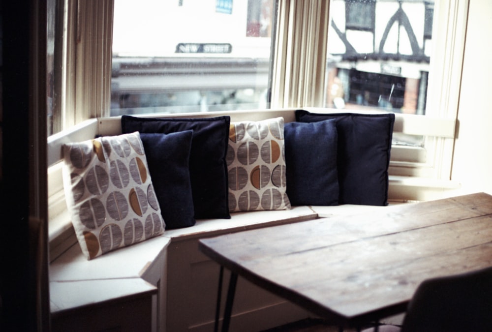 a wooden table sitting in front of a window