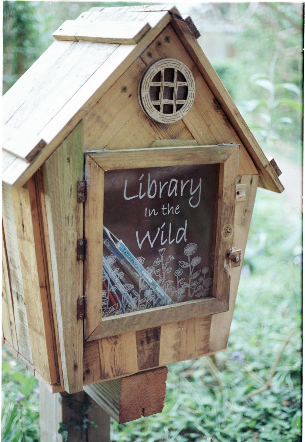 a wooden birdhouse with a sign on it