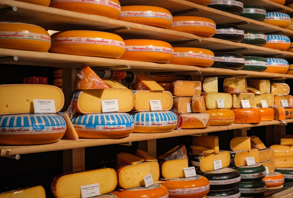 a shelf filled with lots of different kinds of cheese