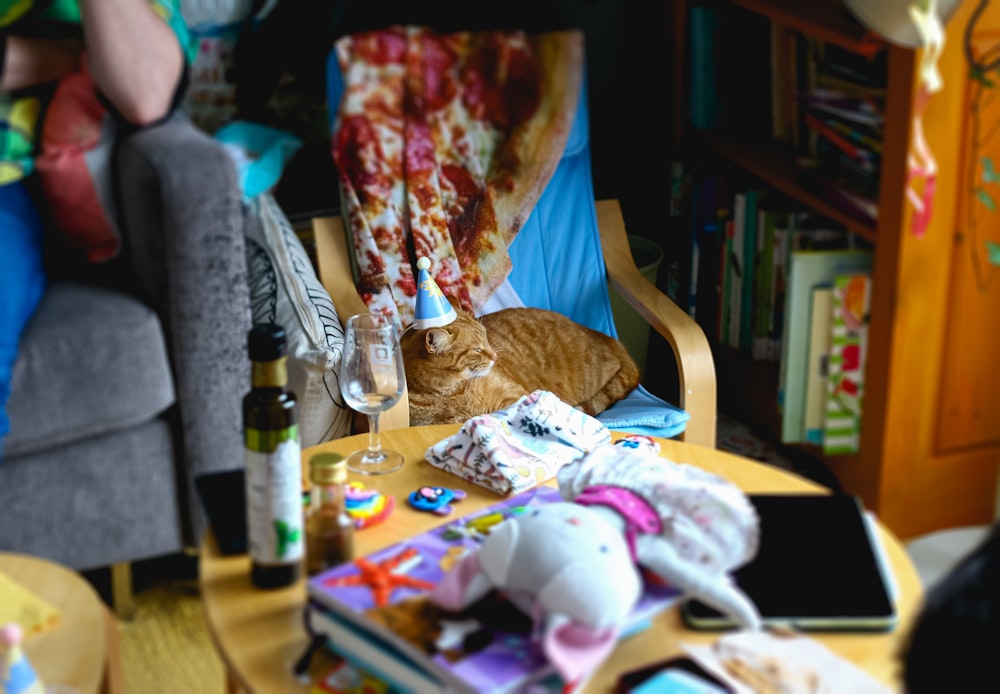 a cat laying on a table with a bottle of wine