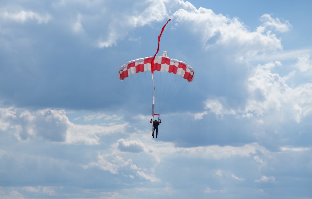 a person is parasailing in the sky on a cloudy day