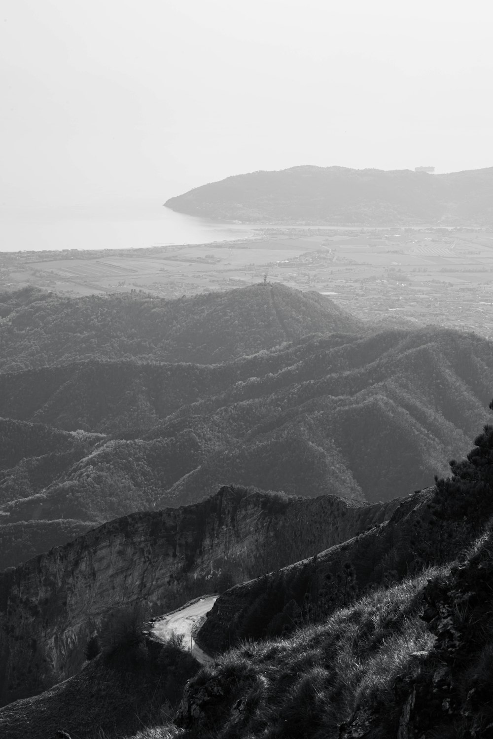 a black and white photo of mountains and a river