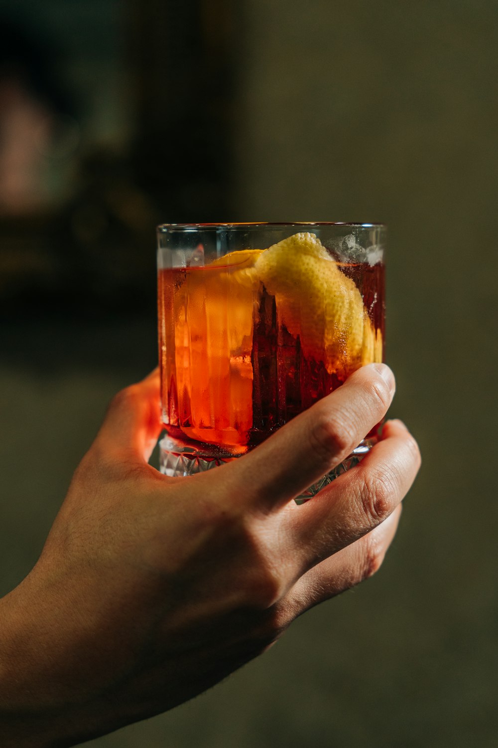 a person holding a glass with a drink in it