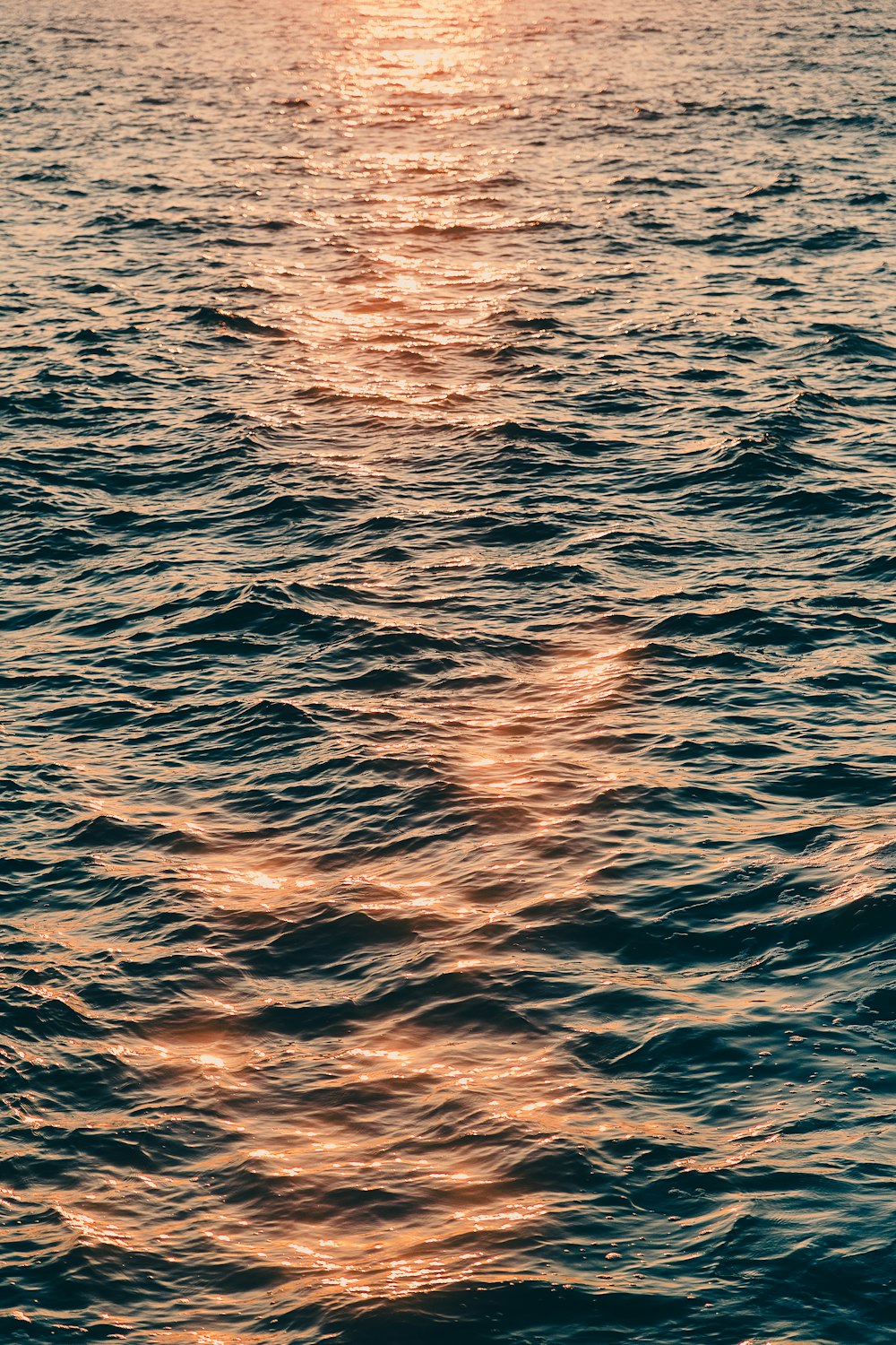 a large body of water with a boat in the distance