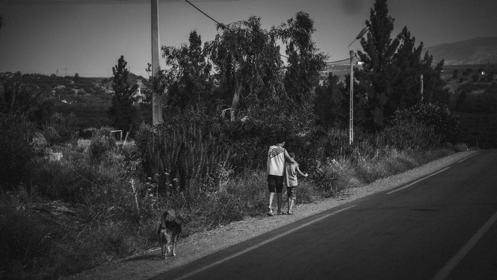 a man and a dog walking down a road