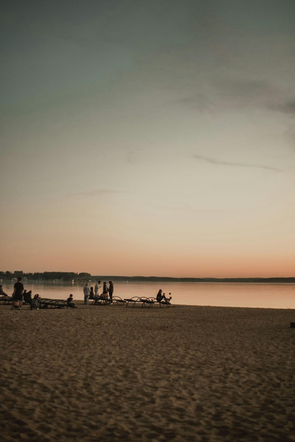 a group of people sitting on top of a sandy beach