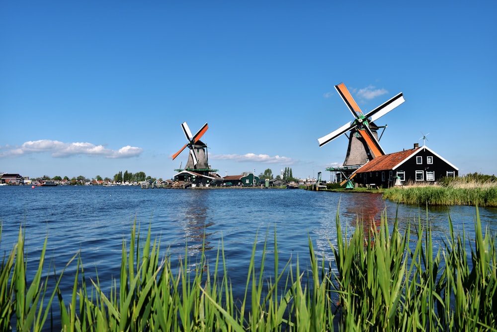 a couple of windmills sitting on top of a lake