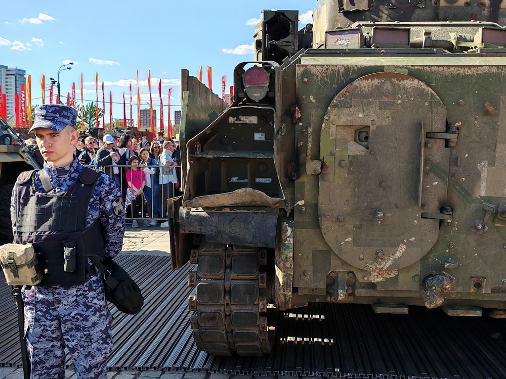 a woman in a military uniform standing next to a military vehicle