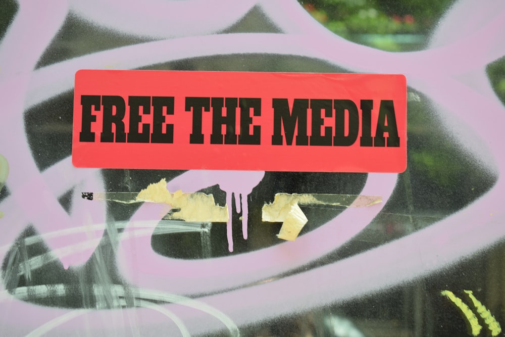 a red sign that reads free the media