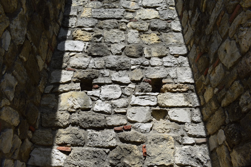 a stone wall with a shadow cast on it