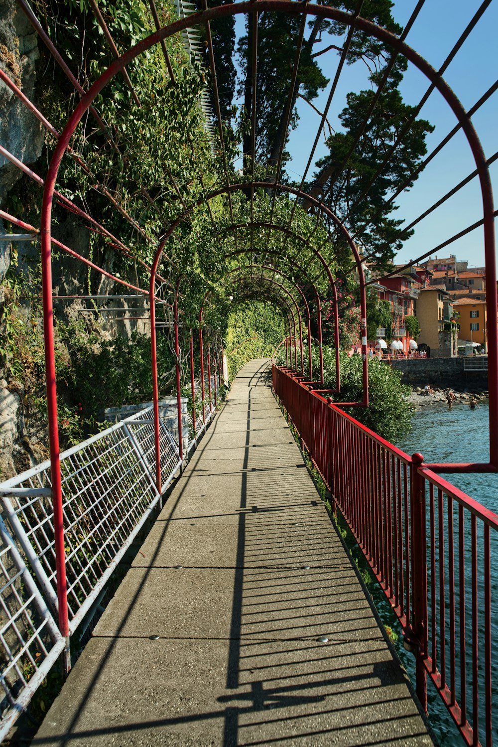 a walkway with a red metal frame and a red railing