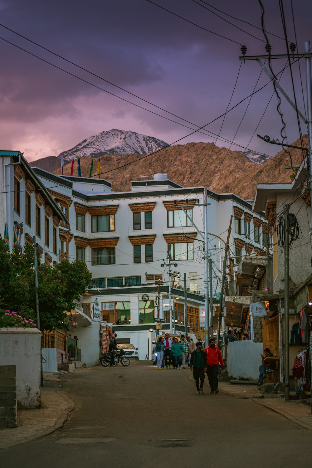 a group of people walking down a street next to tall buildings