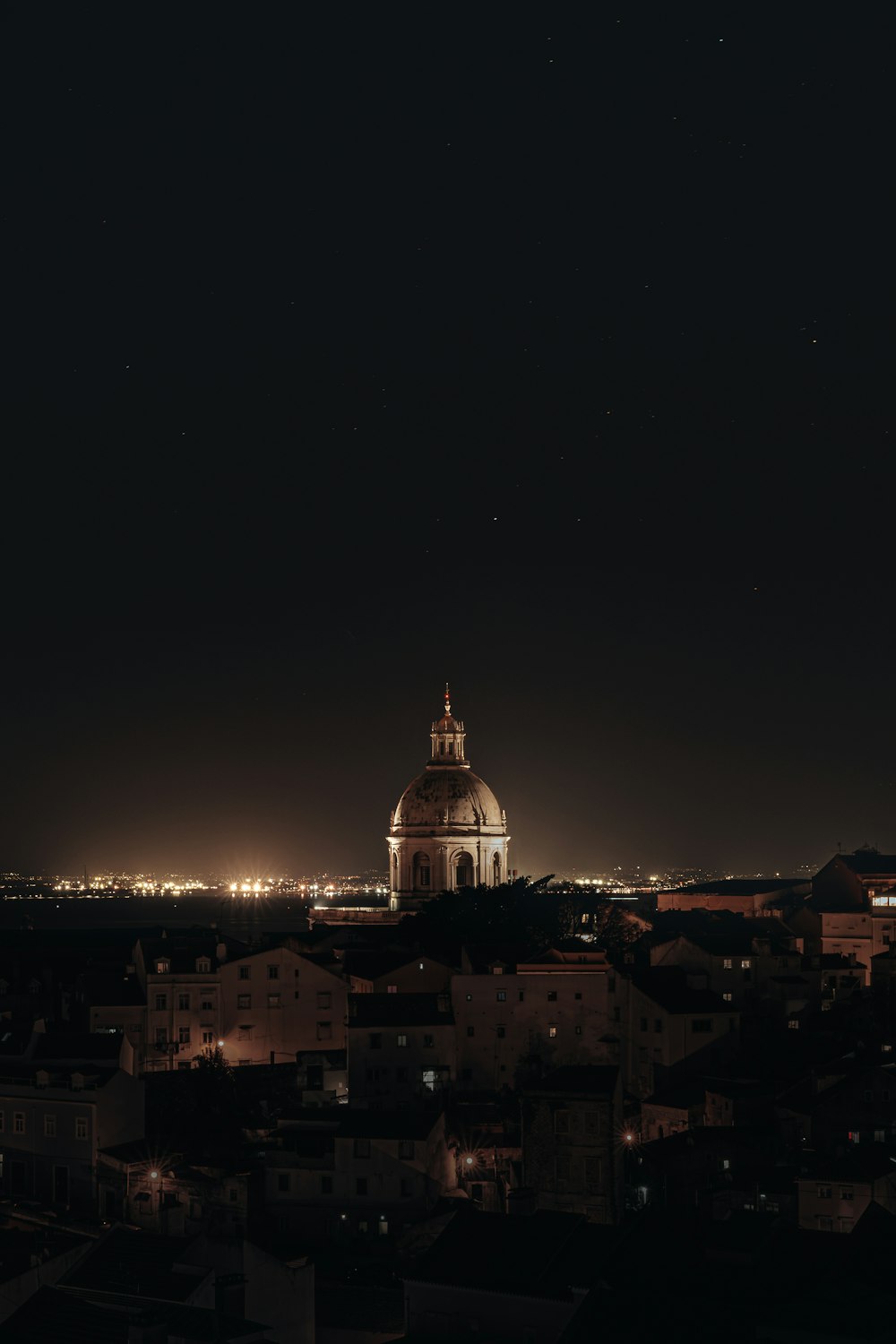 a view of a city at night from a hill