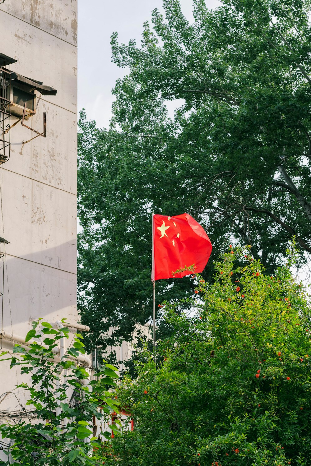 a chinese flag flying in front of a building