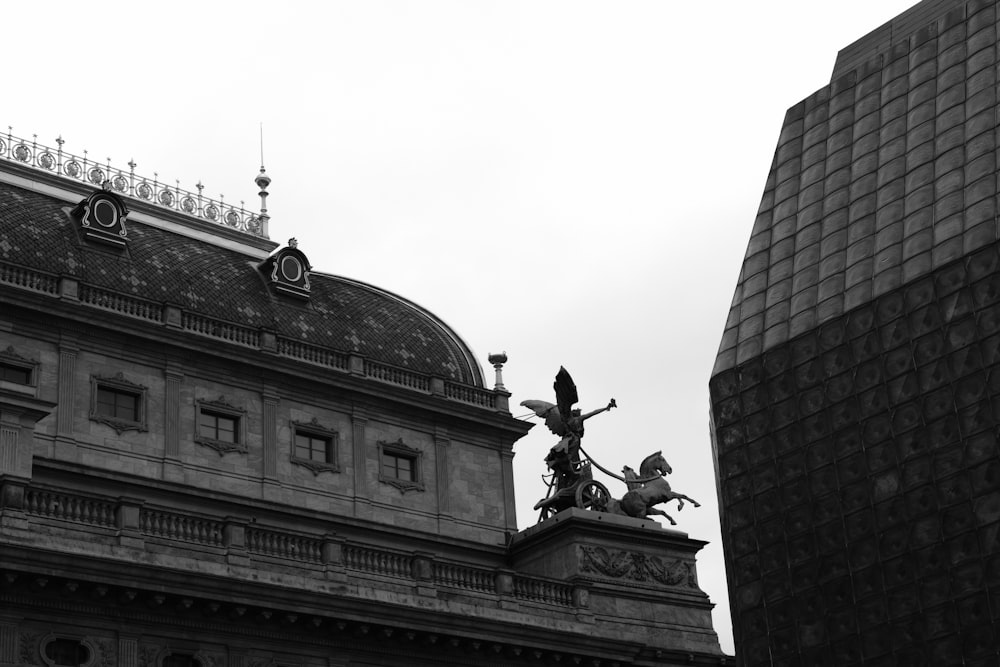 a black and white photo of a building and a statue
