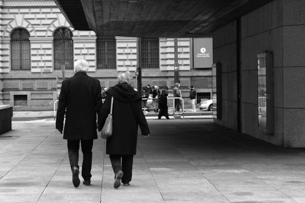 a man and a woman walking down a sidewalk