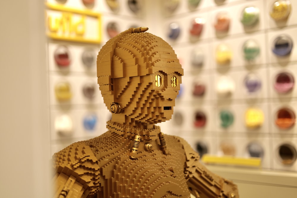 a lego robot is standing in front of a wall of buttons