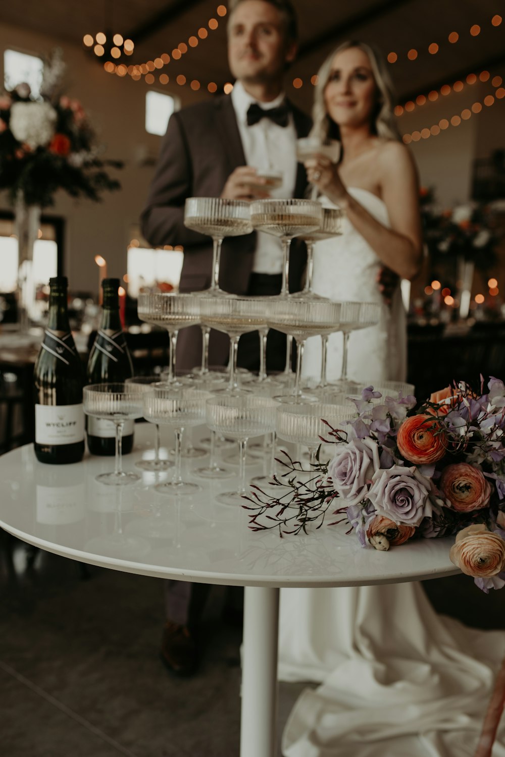 a man and a woman standing next to a table with wine glasses on it