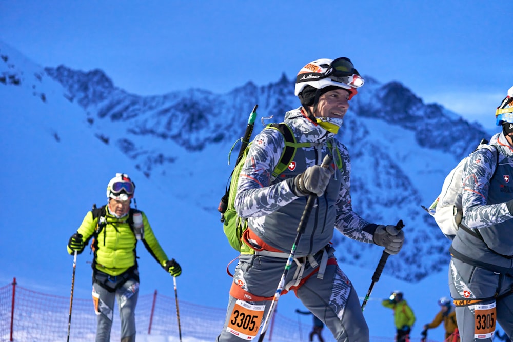 a group of people riding skis down a snow covered slope