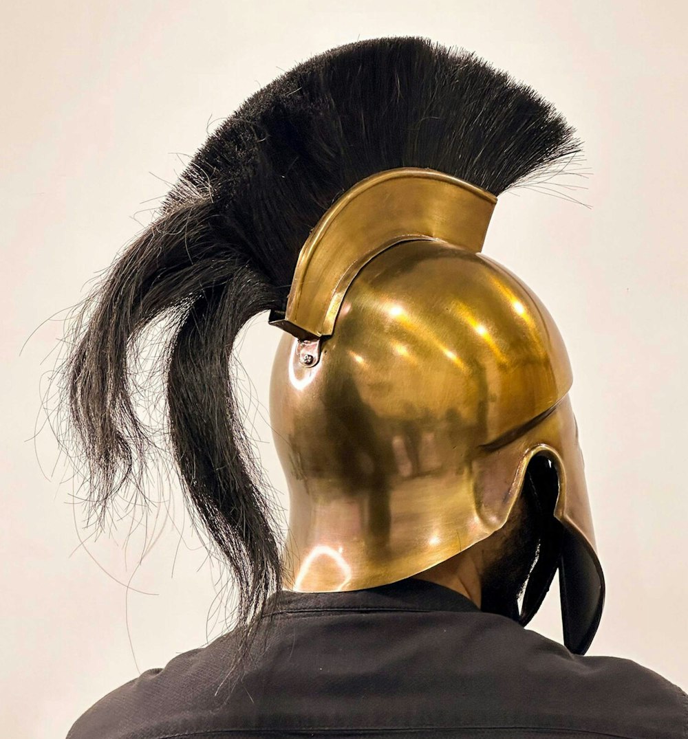a gold helmet with a black mohawk on top of it