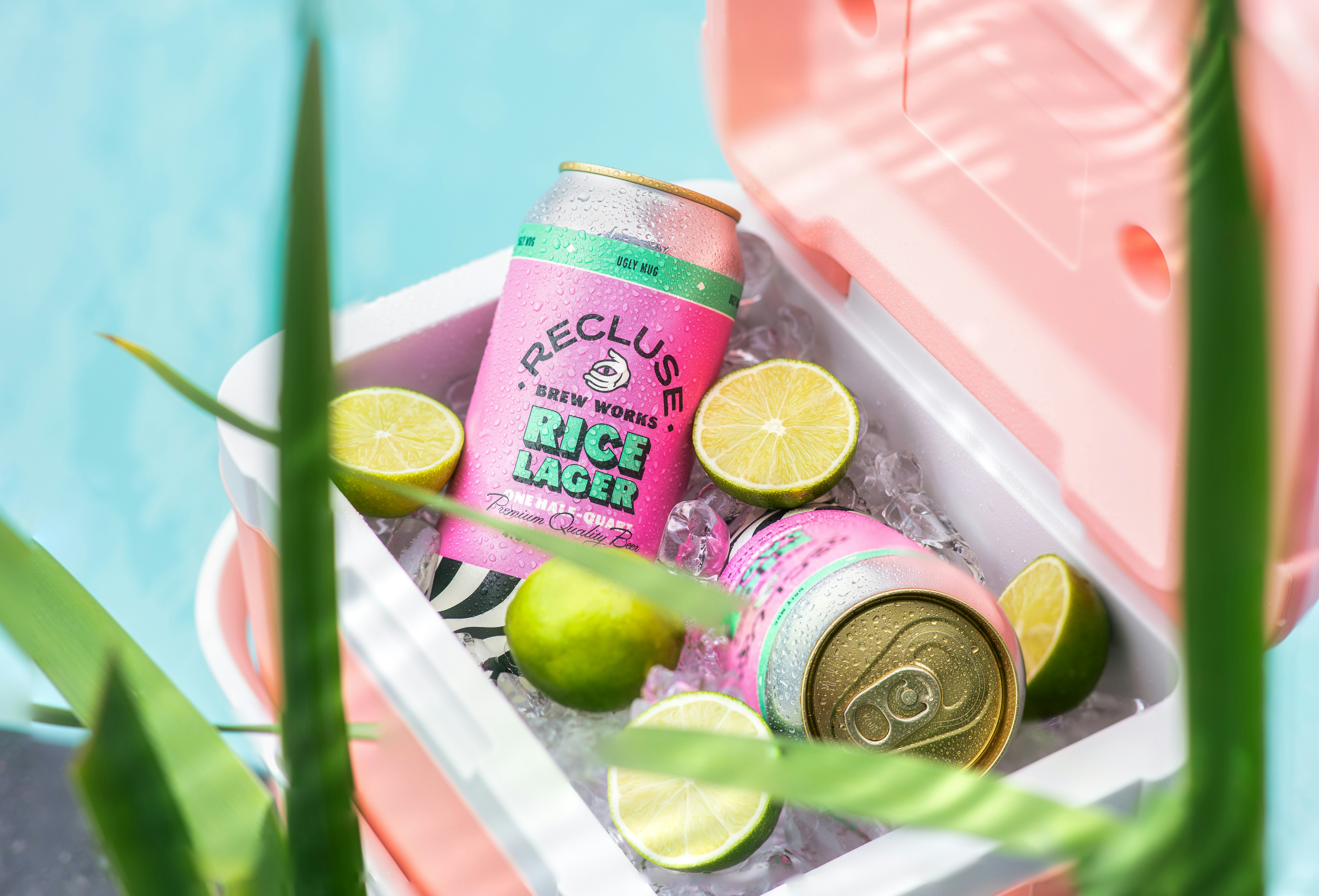 a pink cooler with limes and a can of soda