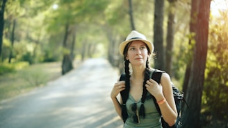 a woman with a backpack is walking down the road