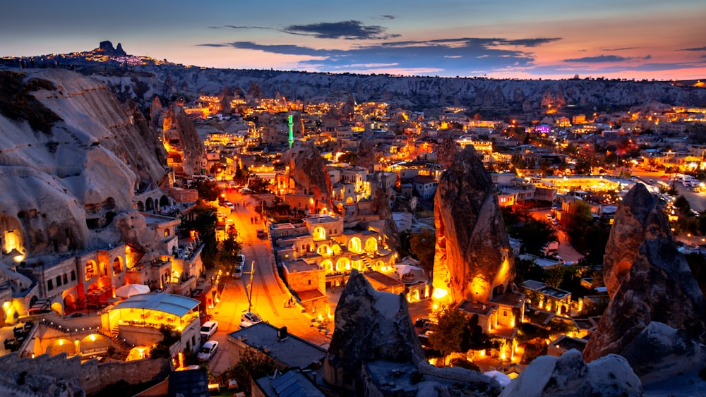 a city lit up at night with mountains in the background