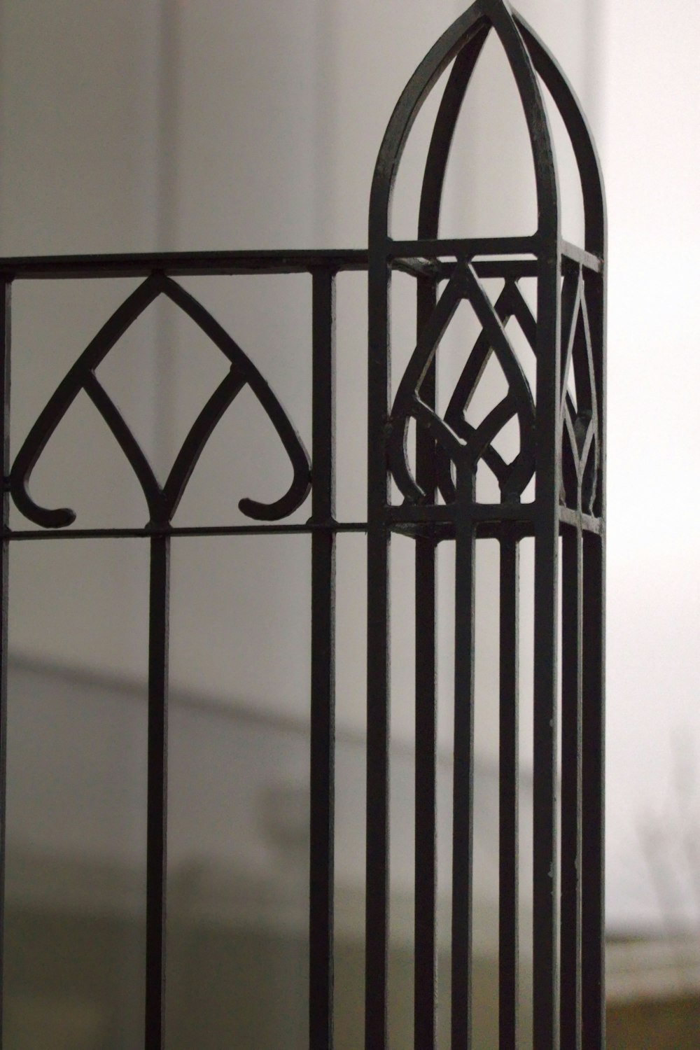 a close up of a metal fence with a building in the background