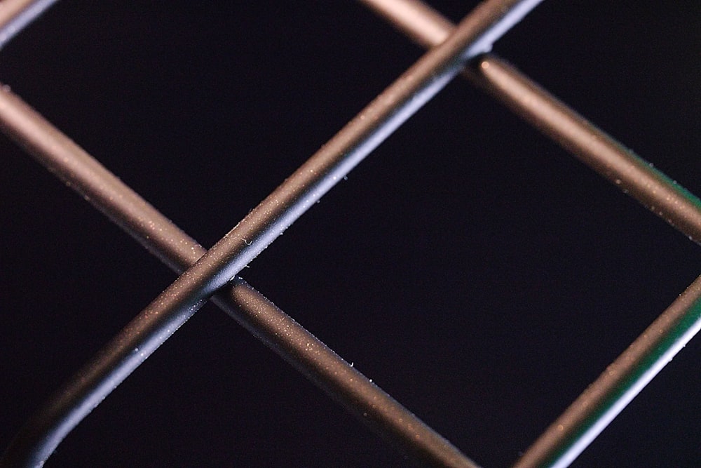 a close up of a metal fence with water drops on it