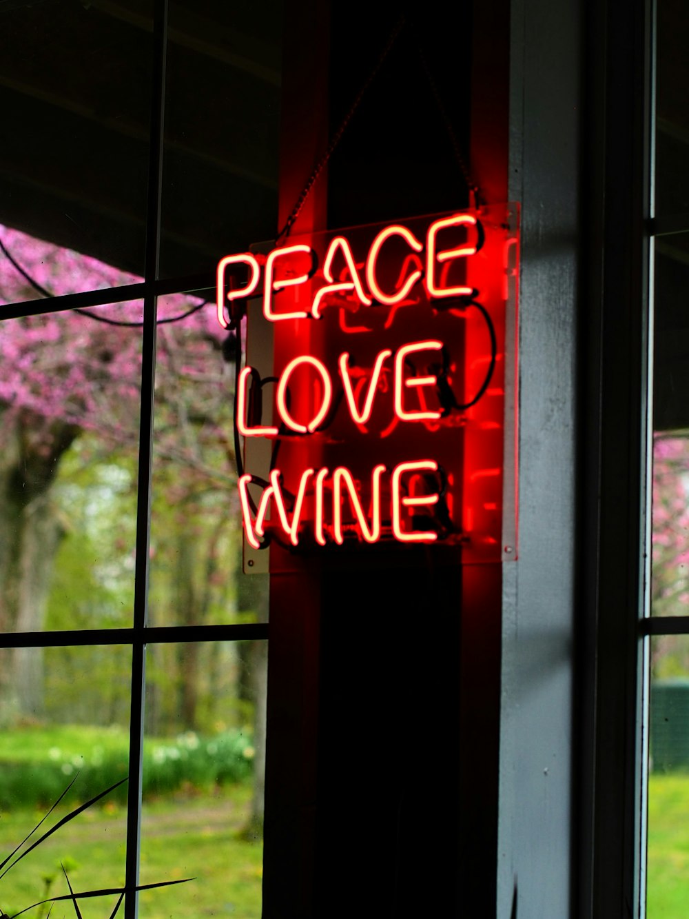 a neon sign that reads peace love wine