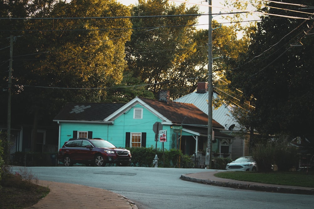 a blue house with a car parked in front of it