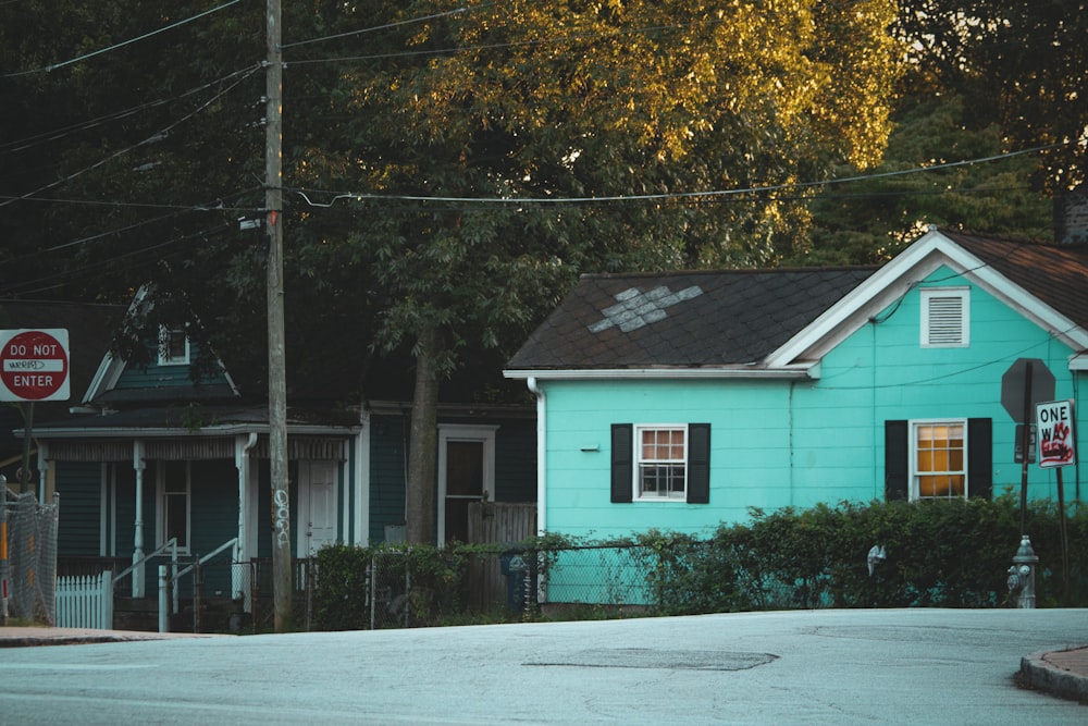 a blue house sitting on the corner of a street