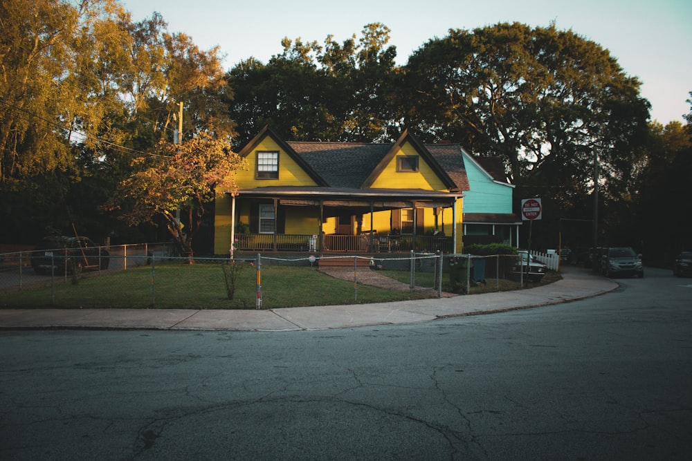 a yellow house with a fence around it