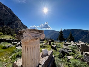 a stone pillar sitting on top of a lush green hillside