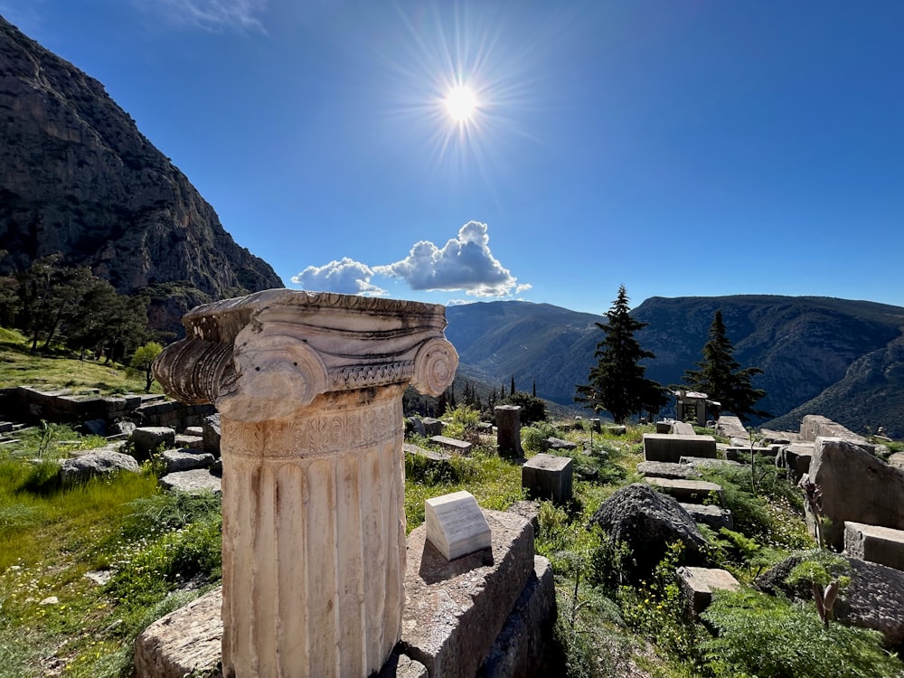 a stone pillar sitting on top of a lush green hillside