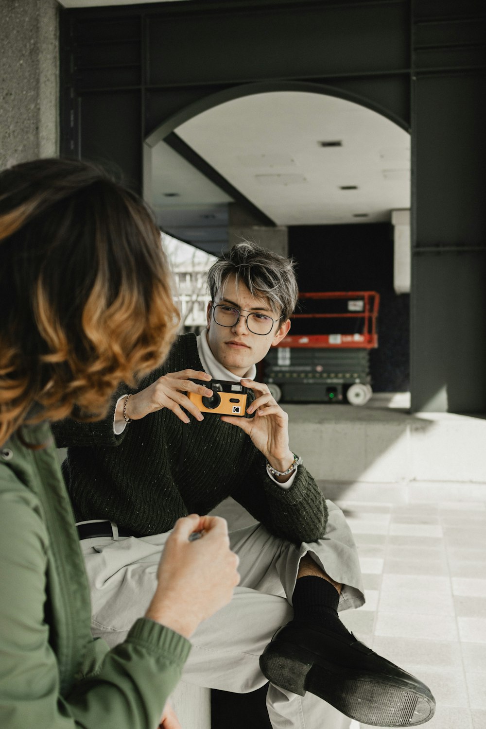 a woman looking at a man wearing glasses