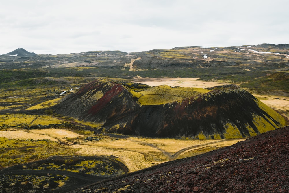 a view of a mountain range with yellow grass