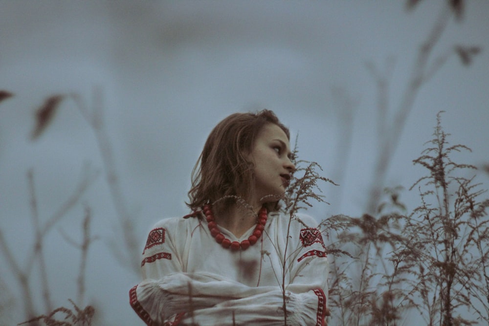 a woman standing in a field of tall grass