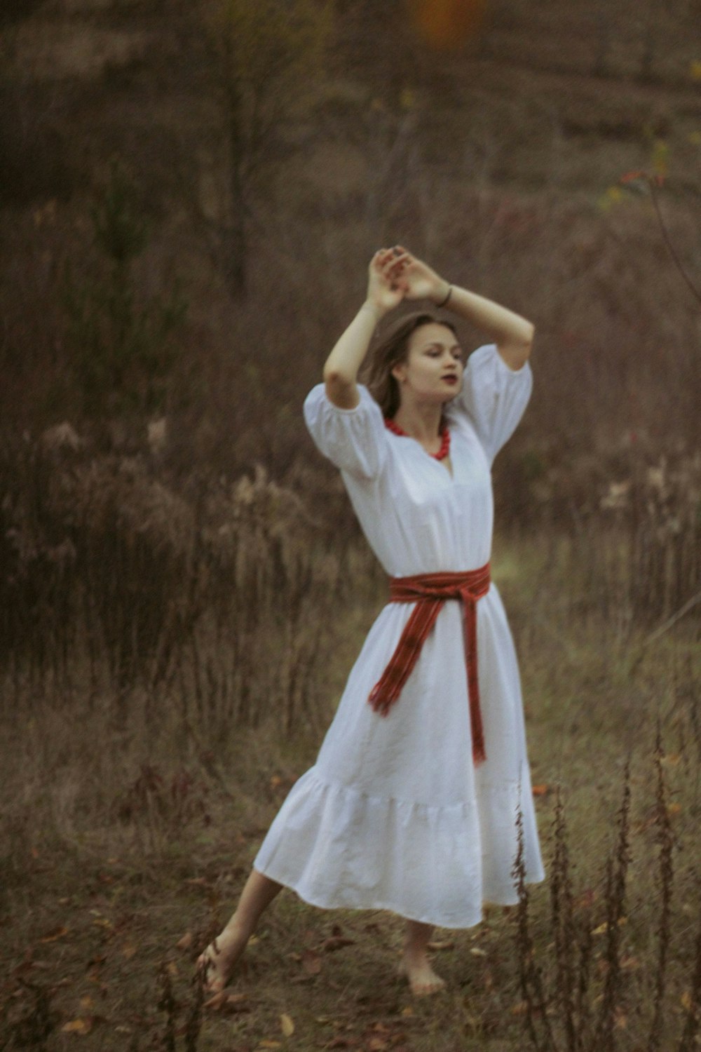 a woman in a white dress standing in a field