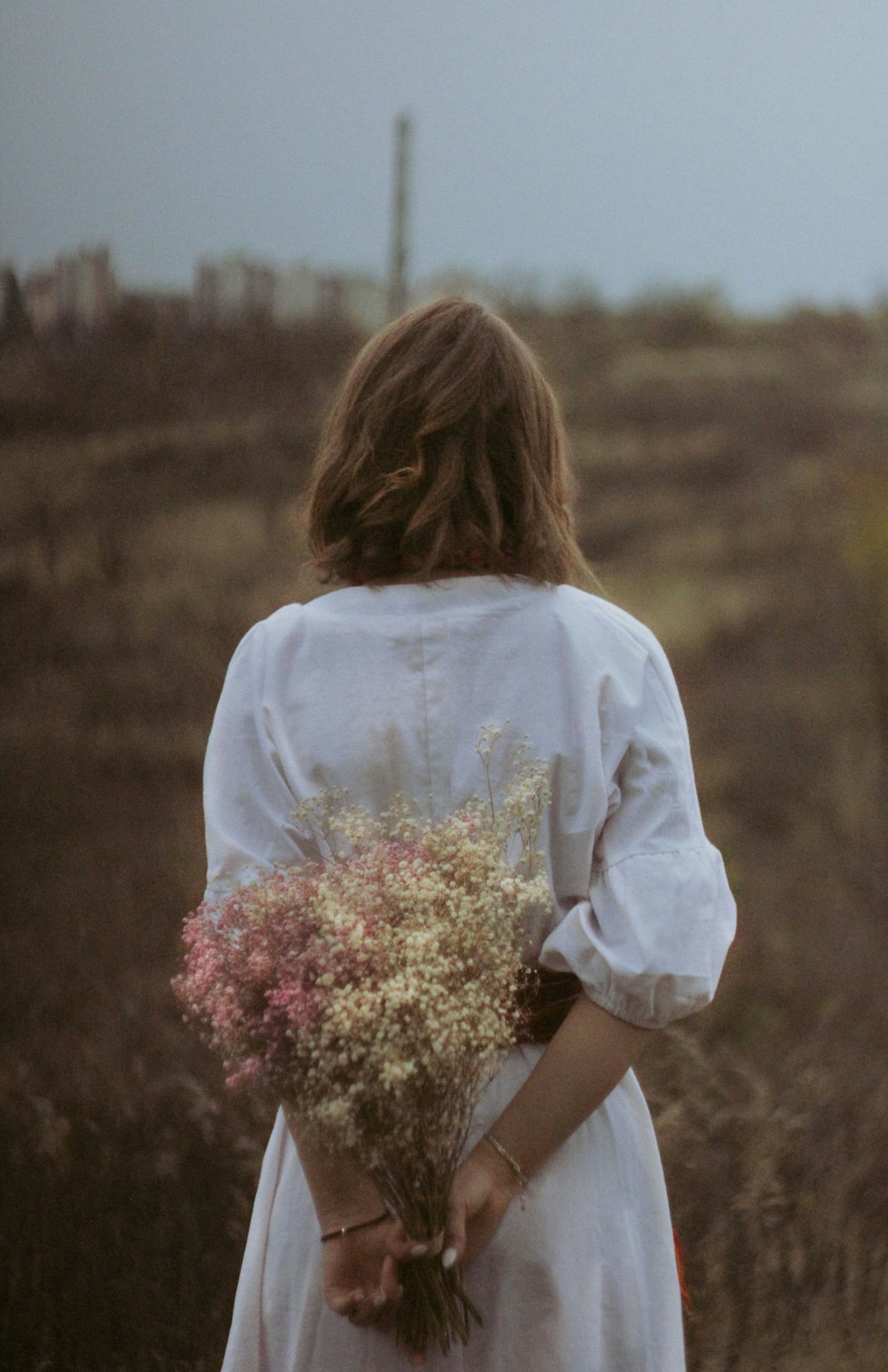 a woman in a white dress holding a bouquet of flowers